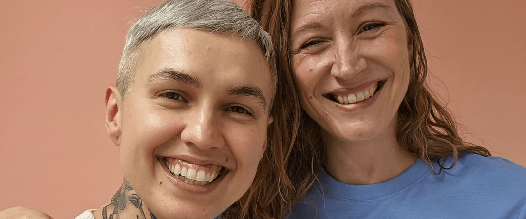 Kaksi naista poseeraa kameralle hymyillen