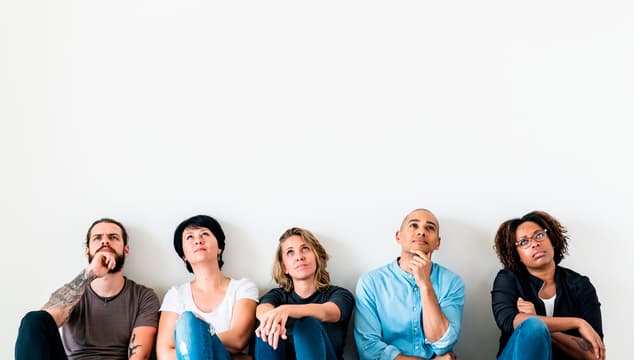 ihmiset istuvat lattialla rivissä ja katsovat ylöspäin ja ihmettelevät